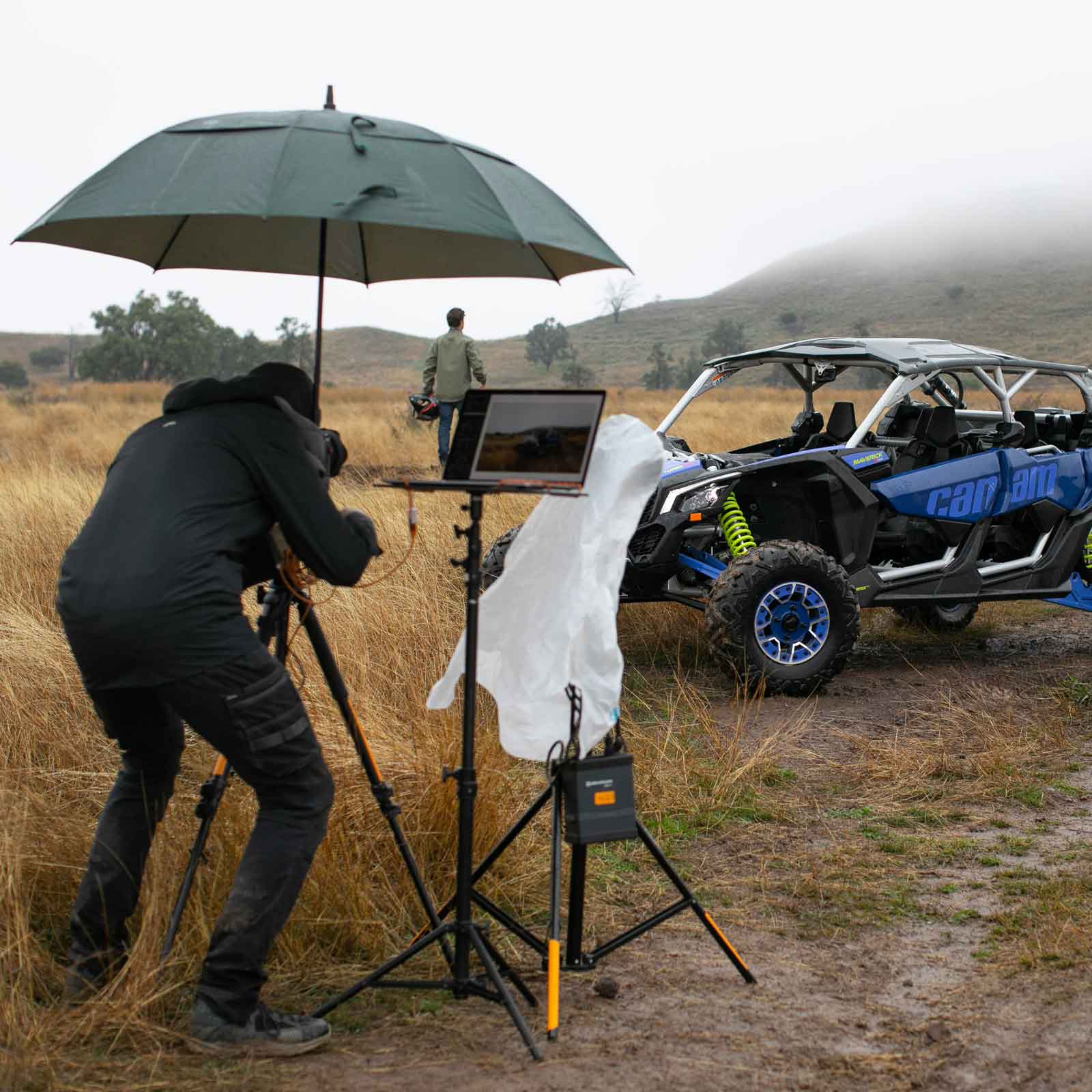 Photographer shooting under an umbrella beside a Can-Am