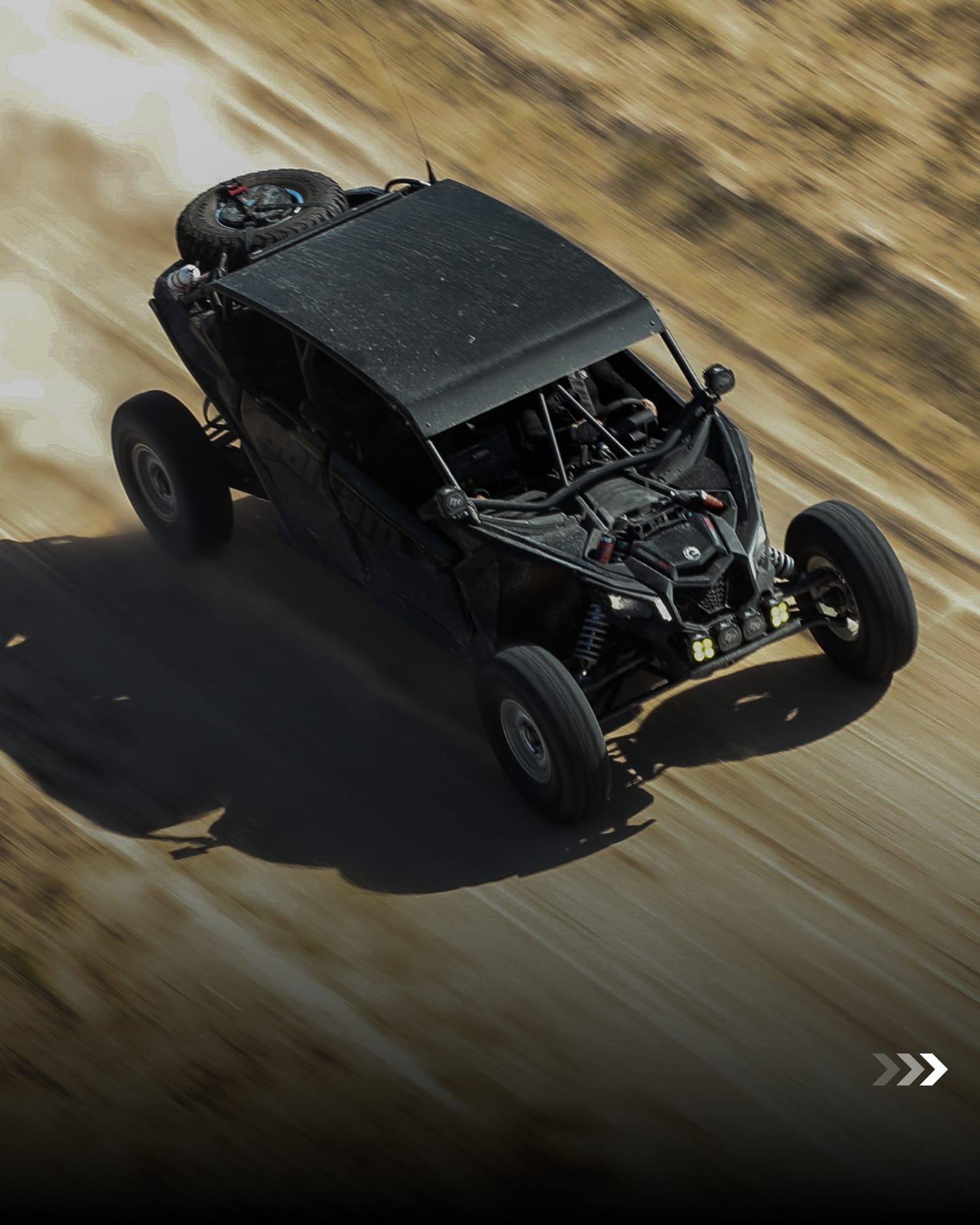 Can-Am side-by-side kicking up dust on a desert track