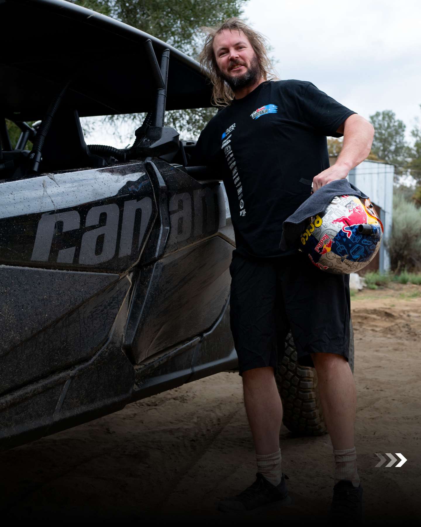Team member with a Red Bull helmet beside a Can-Am