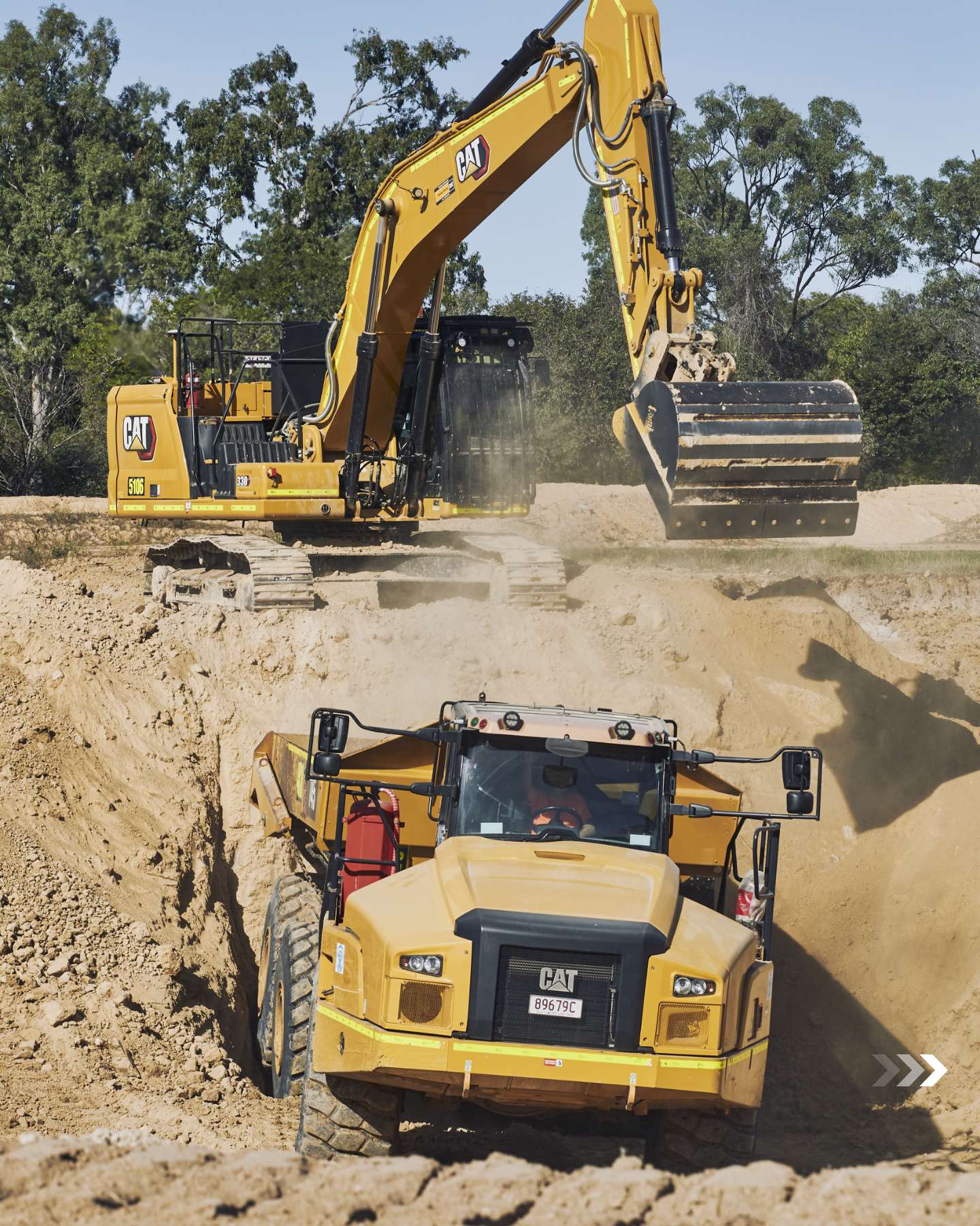Cat excavator loading a Cat dump truck during the build