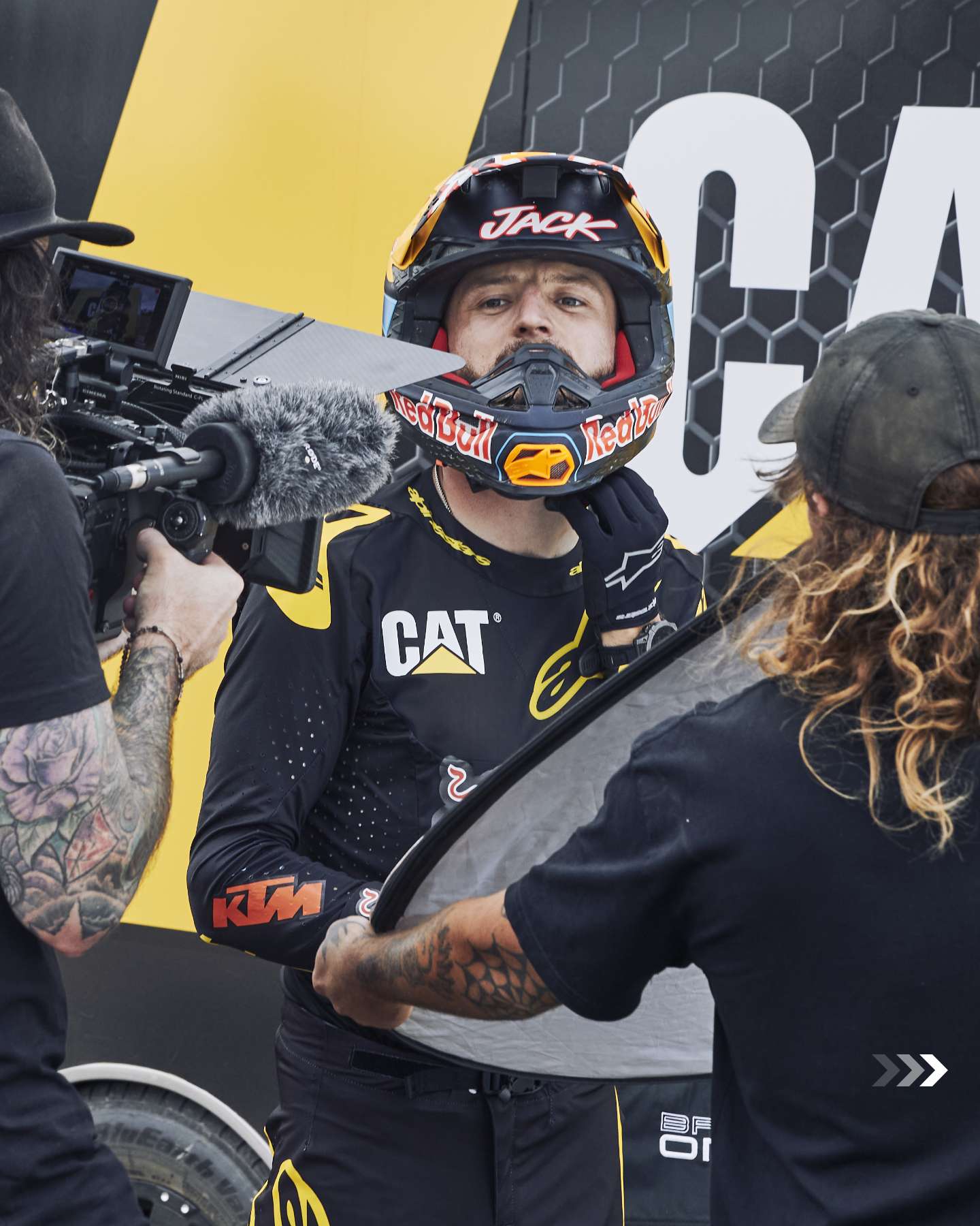 Jack Miller being filmed in front of a Cat backdrop